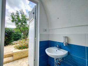 a bathroom with a sink and a door with a window at Tende Glamping Vista Mare Marina Serra in Marina Serra