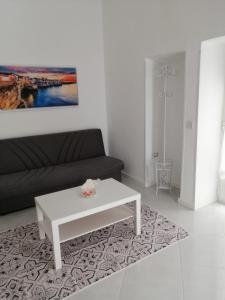 sala de estar con sofá y mesa de centro blanca en Sant'Anna Guest House, en Noicàttaro