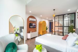 a bedroom with a large white bed and a mirror at SaziHome Ton That Tung Apartment in Ho Chi Minh City