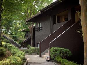 una casa con una fachada negra y escaleras en Laforet Shuzenji Sanshisuimei en Izu