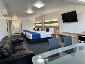 una camera d'albergo con letto king-size e divano di Logan City Motor Inn a Slacks Creek