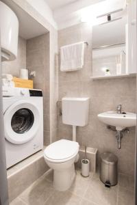 a bathroom with a toilet and a washing machine at Apartment in the old town of Trogir in Trogir