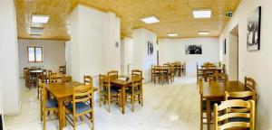 VermoshHotel Vermoshi TDC的用餐室配有木桌和椅子 更多25张照片