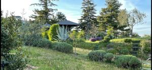 un jardin avec des buissons, des arbres et un kiosque dans l'établissement Bed & Breakfast Montesterlino, à Cesena