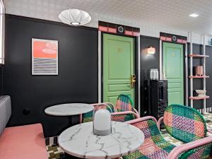 a room with green doors and chairs and a table at Aparthotel AMMI Nice Lafayette in Nice