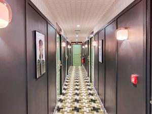 a hallway with a green door and a checkered floor at Aparthotel AMMI Nice Lafayette in Nice