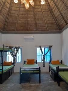 Habitación con 2 camas y techo con ventanas. en The Seaside Bungalow Hostel and Bar, en Hoi An