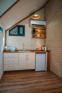 a kitchen with a sink and a brick wall at Woodlife Bungalov in Ardeşen