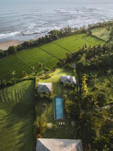 an aerial view of a resort with a swimming pool and the ocean at Balian Prana in Selemadeg