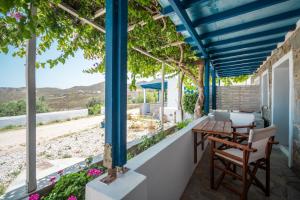 eine Terrasse mit einem Tisch und Stühlen sowie Strandblick in der Unterkunft Niel Serifos in Serifos Chora