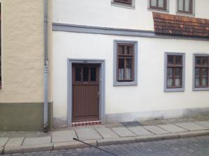 クヴェードリンブルクにあるFerienwohnungQuedlinburgの茶色のドアと窓のある白い建物