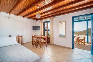 a bedroom with a bed and a table and chairs at Niel Serifos in Serifos Chora