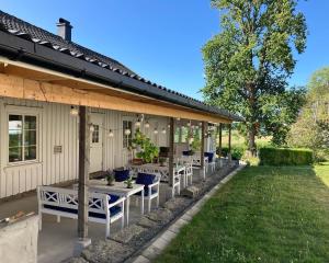 eine Terrasse mit Tischen und Stühlen auf einem Haus in der Unterkunft Bilitt gård in Hobøl