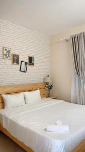 een slaapkamer met een groot bed met witte lakens bij An's Oceanus in Nha Trang