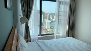 a bedroom with a bed and a large window at An's Oceanus in Nha Trang