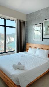 a bedroom with a large bed with a large window at An's Oceanus in Nha Trang