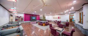 a large room with couches and chairs and a tv at Hotel Ranthambore Regency in Sawāi Mādhopur