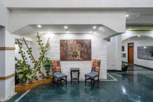 a lobby with two chairs and a painting on the wall at Hotel Ranthambore Regency in Sawāi Mādhopur