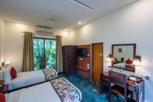 a hotel room with a bed and a desk and a bedroom at Hotel Ranthambore Regency in Sawāi Mādhopur
