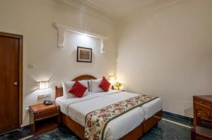 a hotel room with a large bed with red pillows at Hotel Ranthambore Regency in Sawāi Mādhopur