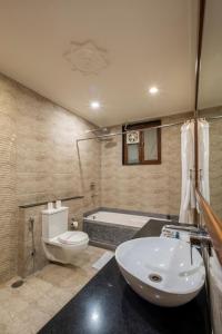 a bathroom with a toilet and a sink and a tub at Hotel Ranthambore Regency in Sawāi Mādhopur