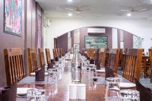 a long table in a restaurant with chairs and glasses at Hotel Ranthambore Regency in Sawāi Mādhopur