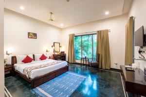 a bedroom with a bed and a large window at Hotel Ranthambore Regency in Sawāi Mādhopur