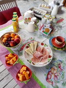 斯廷蒂諾的住宿－Monte Atena B&B di Charme，餐桌,盘子上放着食物和水果碗