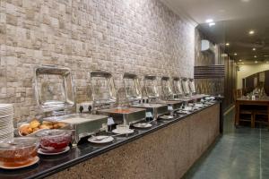 a buffet line in a restaurant with a line of food at Hotel Ranthambore Regency in Sawāi Mādhopur