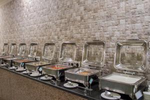 a row of trays of food on a table at Hotel Ranthambore Regency in Sawāi Mādhopur