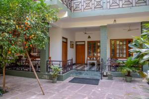 a house with a porch with orange trees at Hotel Ranthambore Regency in Sawāi Mādhopur