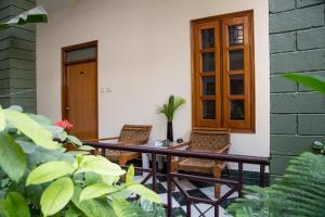 a porch with two chairs and a table and a door at Hotel Ranthambore Regency in Sawāi Mādhopur