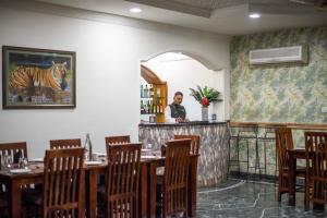 a man standing at the bar in a restaurant at Hotel Ranthambore Regency in Sawāi Mādhopur