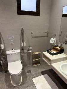 La salle de bains est pourvue de toilettes blanches et d'un lavabo. dans l'établissement سيلين هوم الملقا, à Riyad