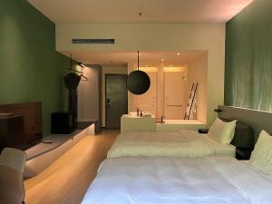 a bedroom with two beds and a television and a bathroom at Zhi Resort Beijing in Beijing
