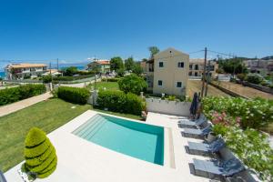 vista sulla piscina e sul prato con sedie di Luxury Seaside Villa DARL a Città di Corfù