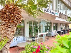 a store front with a table and chairs and flowers at Aura Living Hotel in Rimini