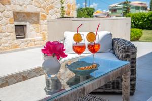 two glasses of wine on a wicker table on a patio at Luxury Seaside Villa DARL in Corfu