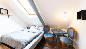 1 dormitorio con 1 cama, mesa y sillas en Silvie Apartments - Masaryk, en Olomouc