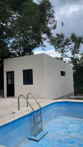 a swimming pool in front of a white building at 1 bedroom home with pool/patio in a Mayan village. in Cuncunul