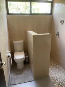 a bathroom with a toilet and a sink and a window at 1 bedroom home with pool/patio in a Mayan village. in Cuncunul