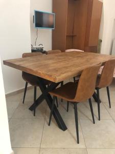 mesa de madera con 2 sillas y TV en casa gramazio, en Manfredonia