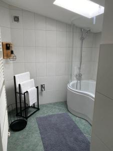 ein Badezimmer mit einer Badewanne und zwei weißen Stühlen. in der Unterkunft Ferienhäuschen Gartenblick in Friedrichroda