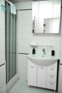 Un baño blanco con lavabo y ducha. en Shabby Roman Studio- ai fori Imperiali, en Roma