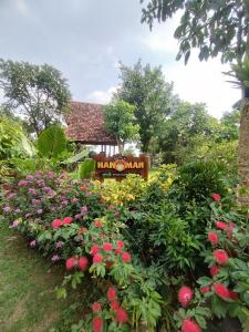 einen Garten mit Blumen vor einem Schild in der Unterkunft Kebun Hanoman Villa in Pablengan