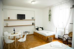 Una pequeña habitación con una cama, una mesa y sillas. en Shabby Roman Studio- ai fori Imperiali, en Roma