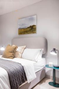 1 dormitorio con 1 cama y una pintura en la pared en Circa Aparthotel by Totalstay, en Pretoria