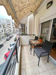 d'un balcon avec une table et des chaises offrant une vue sur la rue. dans l'établissement Philoxenia Oasis Supreme Apartment, à Alexandroúpolis