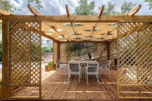 pérgola de madera con mesa y sillas en la cubierta en Villa Korina, en Tria Monastiria