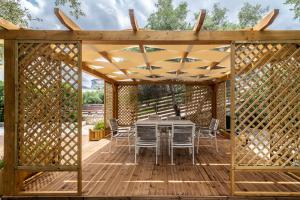 a wooden pergola with a table and chairs on a deck at Villa Korina in Tria Monastiria